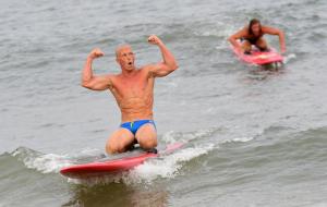 Steve O'Boyle from Middlesex Beach Patrol flexes as he takes first in the paddleboard race.