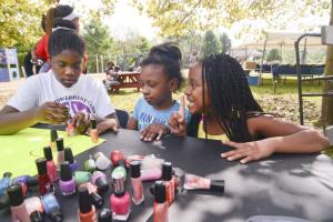 Faith Predeoux paints Jayla Mitchell’s nails, while Jada Thomas makes a choice of color.