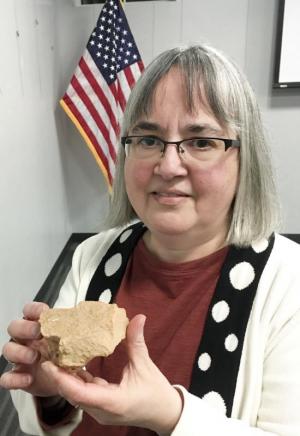 Joanne Caputo shows a piece of a handmade brick from the Gaines Tavern in Walton, Ky.