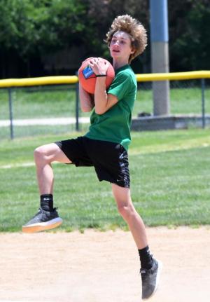 Lex Johnson, 14, makes a leaping catch for an out.