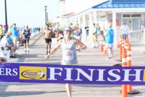 Female winner Natalie Trait finishes strong on the boardwalk.