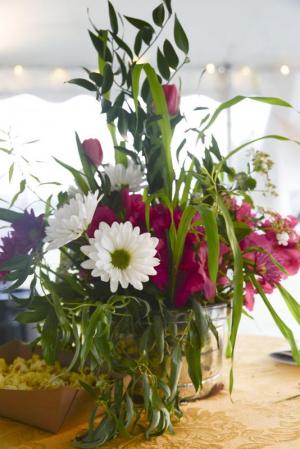 Rustic flower arrangements grace the tables in the tent.