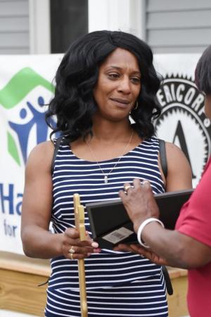 Carmen Blackwell sheds a tear as she receives a prayer presentation from Eleanor Marchtmon, president of the West Rehoboth Community Land Trust.
