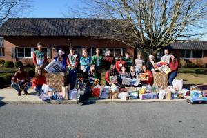 Student volunteers gathered Dec. 19 to load up the gifts that Middle and Upper School students donated. Shown are in back (l-r) Brice Richins, Anika Larsen, Gavin Carmody, Grace Baeurle, Anderson Taylor, Carter McCabe, Arusa Islam, Jack Tucker, Lily Baeurle, Audrey Stearns, Acting Head of School/Head of Upper School Mike Grosso, and Spanish teacher Bianca Perez. In front are Ian Betterson, Kate Abbott, McKenzie Blake, Alessia Matha, Ellie Todorov, Madison Van Orden, and Mesa Cammack.
