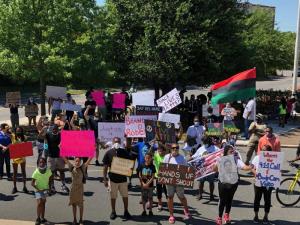 Protesters in front of city hall shout for justice for Brandon Roberts.