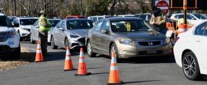 After initial screening, participants in the mass vaccine clinic in Dover prepare to drive through one of four lanes set up to handle the large crowd.