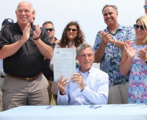 Gov. John Carney celebrates signing the new clean water law. Pictured are (l-r) Schwartzkopf; Joanne McGeoch with the Delaware Nature Society; Carney; Lopez; and Longhurst.