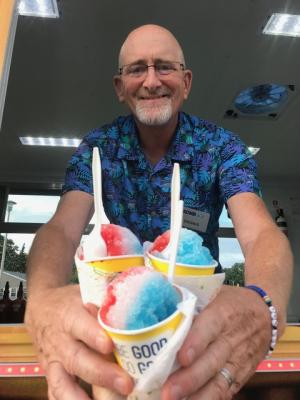 Kona Ice local franchise co-owner Dennis Noonan serves cool treats in patriotic colors.
