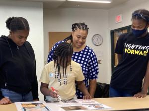 Putting the finishing touches on her group’s poster is Le’Andria Sunkett. Group members shown in back are (l-r) Saniyah Parker, Carmen Sunkett and Liberty Hanzer.