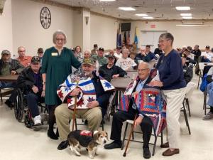 Vietnam Veterans of America National President Jack McManus, left, and Regional President Ted Wilkerson, each receive a Quilt of Valor for their military service, flanked by Dana Mason, far left, and Marguritte Niemoeller, far right, along with service dog, Charlie.