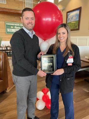 Tracy Belcher, right, of Beebe Healthcare accepts the second-place plaque for raising $31,000, from Dave Morris, American Heart Association executive director.