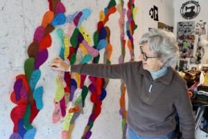 JoEllen Jordan places a small footprint on the wall in Sarah Pavlik’s studio.