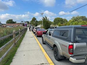 Cars line Magnolia Street in Milton waiting to get free gas and a car wash.