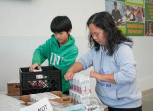 Max Wu and his mother, Lixin Wang, of Hockessin, pack meal kits at the MLK Jr. Day of Service in Milford. Wu, a Boy Scout, is volunteering to earn a merit badge.