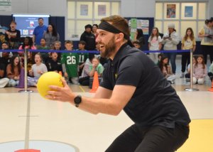 Catching a throw from a fifth-grader, school psychologist Alex Albanese earns an out.