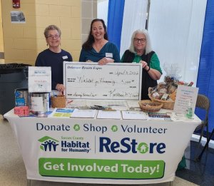Kathy Benson, owner of Delaware Resorts Expos, presents a $1,000 donation to Sussex County Habitat for Humanity. Shown are (l-r) Habitat volunteer Patricia Reuter, Benson and Habitat volunteer Becky Good.