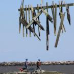 Workers assess the remaining pier. BY MELISSA STEELE