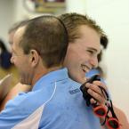 Cape assistant coach Rick Brokaw gives senior John Dean a hug after his performance in the 400 free relay that clinched the championship for the Vikings. BY DAN COOK