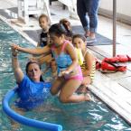 Volunteer Mo DeMay assists Michaella Chacon as she jumps into the deep end. BY DAN COOK