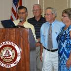 State Rep. Stephen Smyk, R-Milton, left, reads a tribute from the State House of Representatives to the Milton Fire Department Ladies Auxiliary during a celebratory luncheon Aug. 8 alongside state Rep. Harvey Kenton, R-Milford, former state representative George Carey and auxiliary president Mary Ann Warrington. BY MADDY LAURIA