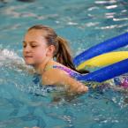 Logan Marvek, 12, practices strokes using her pool noodles. BY DAN COOK