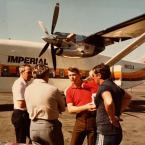 Blouin (center in red shirt) holding his son while talking with colleagues at Imperial Airlines in California. Blouin was a pilot and executive for the company. BOB BLOUIN PHOTO