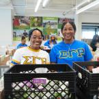 Jasmine Smith, left, and Shawnese Adger, members of the Dover chapter of Sigma Gamma Rho, smile as they pack meal kits.