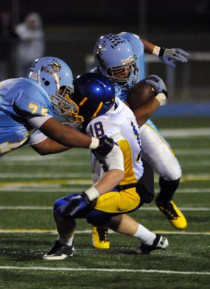 Cape guard Spencer Brittingham, left, blocks Central's No.18 Jacob Miller to spring Jerome Johnson for a long gain. BY DAN COOK
