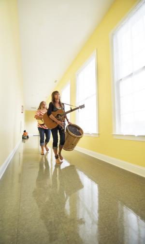 Cathy Bostaph and Anna DiNenna of Bethany's Scrubgrass and Langly head to the stage with bells, drums and guitars. BY DENY HOWETH