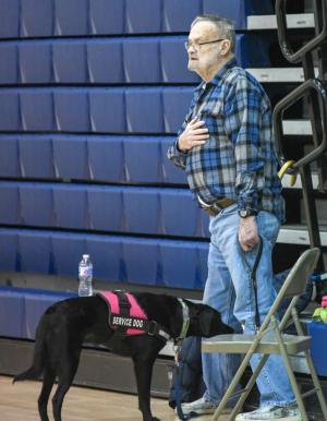 John Collins and his service dog Mahi rep respect during the national anthem at Sussex Central. DAVE FREDERICK PHOTOS
