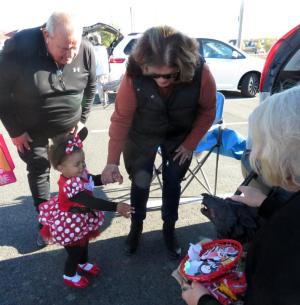All eyes are on Olivia Davis, dressed as Minnie Mouse, as she greets the friendly black dog protecting a candy stash. Shown are (l-r) grandparents Richard and Debbie Hendrickson, Olivia Davis, and volunteer Pat Scheivert. SUBMITTED PHOTOS